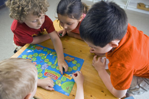 Children have fun and learn while playing a board-game at the preschool class.